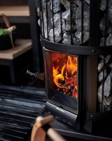 Harvia Legend 240 GreenFlame 15.9kW Wood-Burning Sauna Stove with fire burning and sauna stones