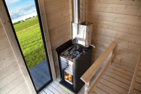 Harvia Pro 36 31kW Wood-Burning Sauna Stove installed in a sauna cabin with window view