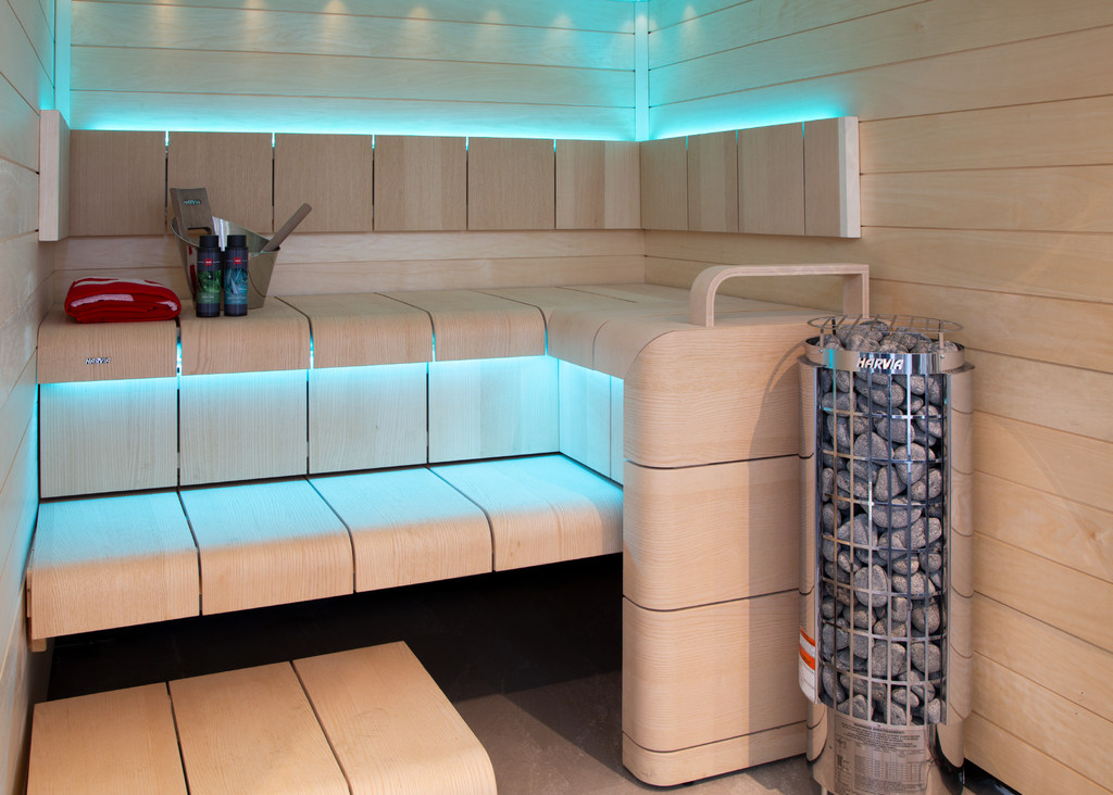Harvia Cilindro PC90 9kW Sauna Heater in a sauna with blue accent lighting and white benches