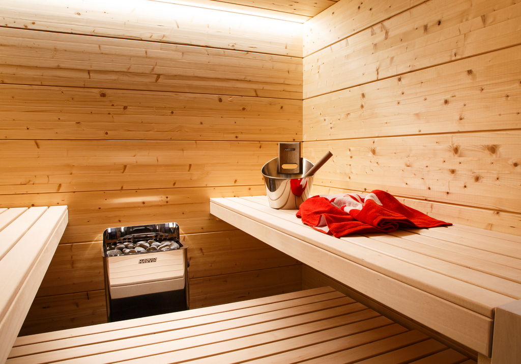 Harvia The Wall 8kW electric sauna heater installed in a sauna with wooden benches