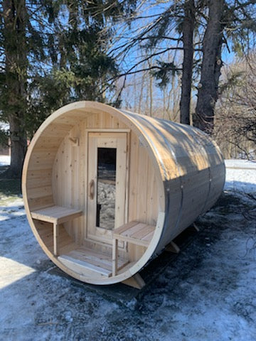 Front view of the Dundalk CT Serenity 5-Person Outdoor Barrel Sauna in the snow