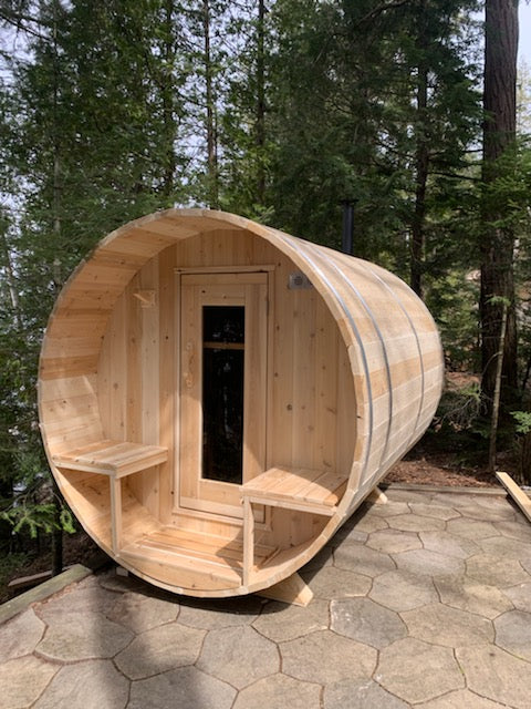 Angled front view of the Dundalk CT Serenity 5-Person Outdoor Barrel Sauna on gravel