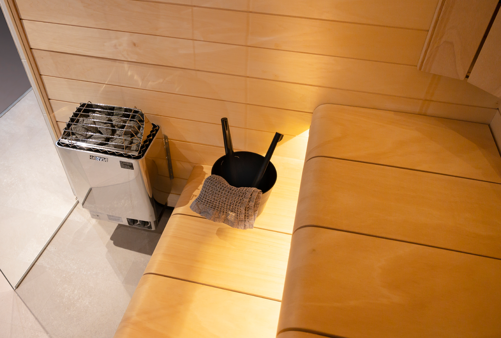 Harvia KIP 8kW Sauna Heater in a sauna with ladle and wooden benches