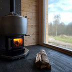 Narvi Luosto VS 16kW wood burning sauna stove with fire burning in a sauna with a large window