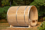 Side view of the Dundalk CT Serenity 5-Person Outdoor Barrel Sauna on a lawn beside trees