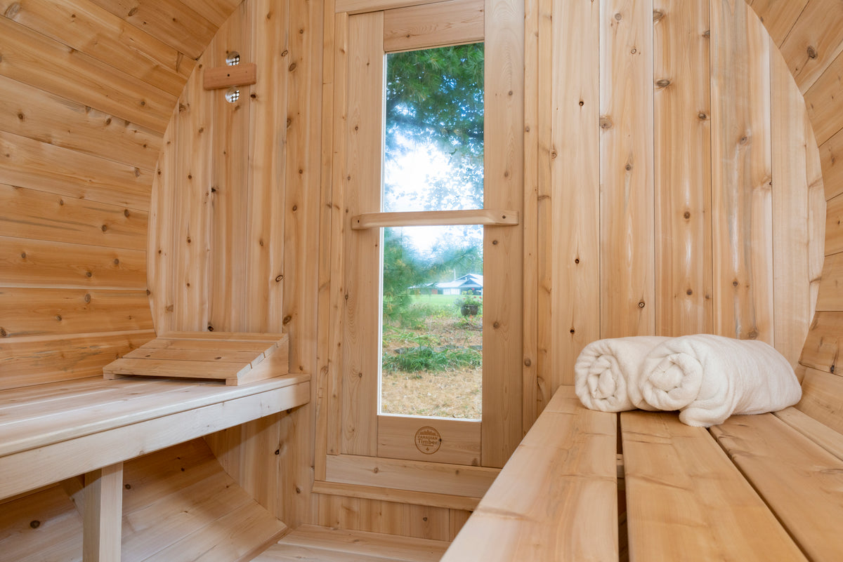 Interior of the Dundalk CT Serenity 5-Person Outdoor Barrel Sauna with window, bench and towels