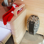 Harvia Spirit 8kW Sauna Heater mounted beside a sauna bench with bucket and towel